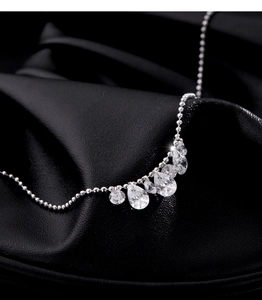 Close-up of sparkling geometric zircon pendant on a silver bead chain necklace