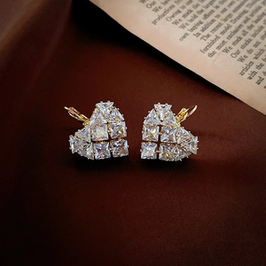 Detailed view of heart-shaped earrings with sparkling cubic zirconia on a gold base