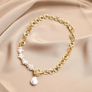Baroque pearl necklace with gold chain and toggle clasp on elegant champagne satin