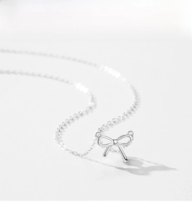 Macro d'un pendentif nœud en argent sterling 925 montrant la finition polie et la chaîne fine