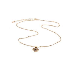 Close-up of golden heart pendant necklace with colorful zircons and beaded chain detail