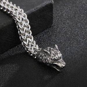 Macro view of a 304 stainless steel wolf head clasp on a woven metal chain bracelet