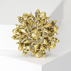 Golden vintage floral brooch with intricate镂空 design and secure pin closure back