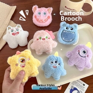 Vista de cerca de broches de monstruos de peluche coloridos con ojos bordados y textura