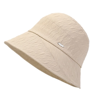 Foldable beige sun bucket hat with wrinkled texture and metal detail for women