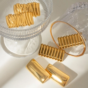 Golden 18k gold plated geometric square earrings with wavy texture on white surface