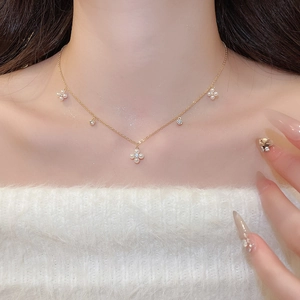 Close-up of elegant gold plated necklace featuring pearl flower pendants and zircon accents