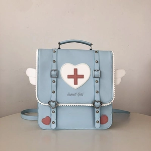 Detail of light blue backpack with Sweet Girl text, heart buckle and white wing charms