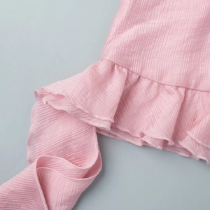 Macro detail of pink crinkled fabric with ruffled edges and fine lockstitch finish