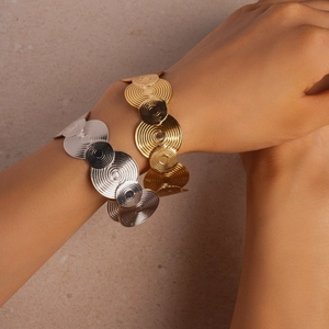 Macro detail of gold and silver open bangles with geometric spiral concentric circles