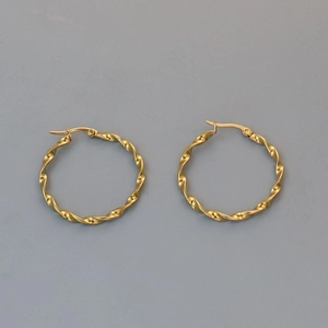 Detailed view of golden twisted hoop earrings with textured finish and secure clasp