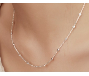 Close-up of 925 sterling silver chain necklace with polished beads on model neck