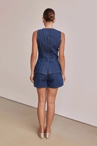 Vista posteriore del set denim blu scuro con gilet senza maniche e pantaloncini a vita alta