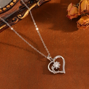 Détail du collier cœur en argent avec motif floral délicat et zircons brillants incrustés