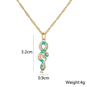 Macro detail of 18K gold plated snake pendant with green enamel and white zircons