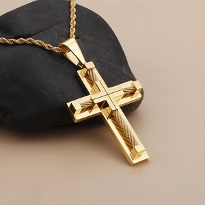 Macro shot of double-layer gold cross pendant with woven texture and twisted chain