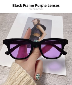 Detail view of bold black square frame sunglasses with purple tinted lenses and thick resin