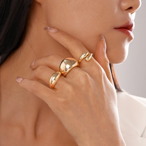 Détail de trois bagues dorées polies en forme de goutte pour un look élégant