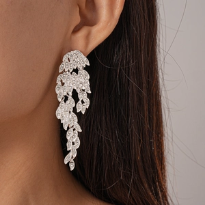 Detail shot of vintage leaf drop earrings with silver pins and pavé crystal rhinestones