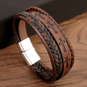 Macro shot of vintage multi-layer braided leather bracelet with cross and magnetic clasp
