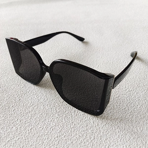 Detail view of stylish black oversized square sunglasses with polished frames and dark lenses