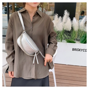 Detailed close-up of a silver lychee pattern crossbody bag with metal chain and tassel zip