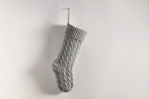 Close-up of grey knitted Christmas stocking with cable knit texture and hanging loop
