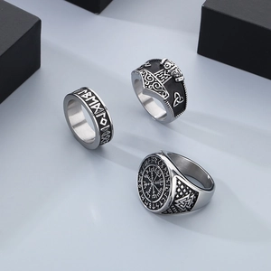 Close-up of three vintage Viking rings with Norse runes and Valknut symbols in silver