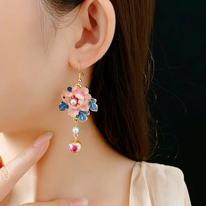 Close-up of vintage flower earrings with pearls and tassel on a female model