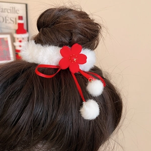Detail of plush red flower hair scrunchie with soft white fur and velvet ribbons
