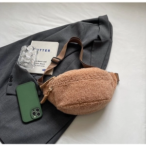 Brown fuzzy crossbody bag shown on a grey blazer with stylish lifestyle props