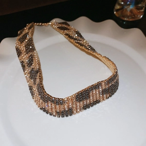 Detailed view of rhinestone leopard print wide choker necklace on a white ceramic plate