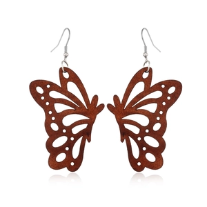 Detail of wooden butterfly earrings featuring fine openwork carving and silver hooks