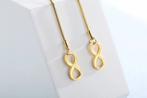 Macro shot of gold infinity pendant with smooth snake chain and polished metal texture