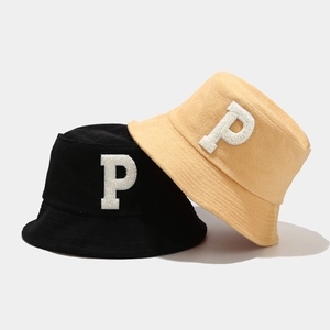 Bobs minimalistes en tissu bouclé avec écusson P brodé en noir et jaune pâle