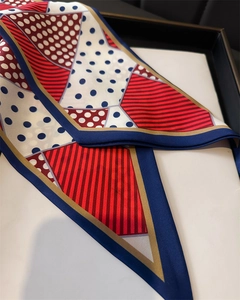 Detail view of polka dot silk scarf featuring red and blue geometric patchwork design