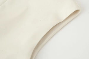 Close-up of cream white square neck vest showing fabric texture and fine edge stitching