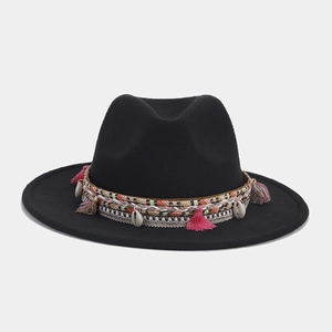 Detalle de sombrero bohemio negro con encaje, conchas y borlas de colores