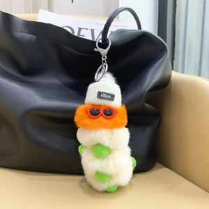Close-up of a colorful plush caterpillar charm with sunglasses on a black handbag