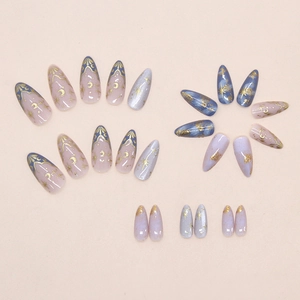 Detail of star and moon almond press-on nails with nebula marble and gold accents