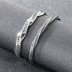 Détail macro des gravures de runes nordiques et texture tressée sur le bracelet