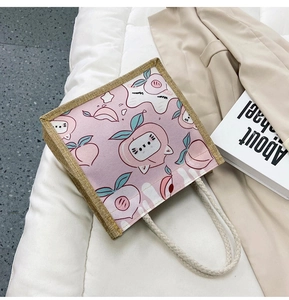 Detail view of canvas tote featuring cute peach cartoon print and cotton rope handles