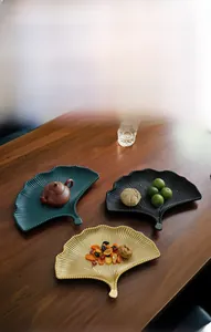 Detail van ginkgo blad decoratieve dienbladen in groen, zwart en goud voor interieur