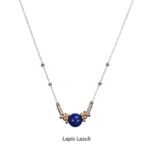 Detailed view of Lapis Lazuli sphere pendant with golden beads on stainless steel chain