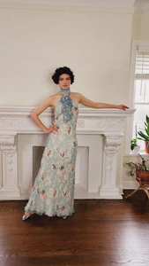 Dettaglio di un abito lungo a fiori azzurro con balze e colletto alto alla moda