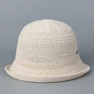 Detailed view of the beige knit bucket hat showing intricate mesh pattern and texture