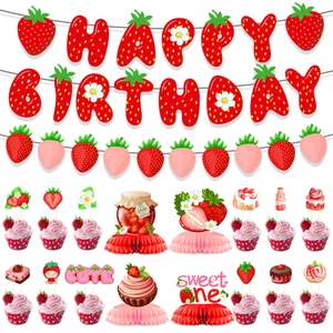 Flat lay of strawberry party set with Happy Birthday banner and cupcake toppers