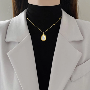 Minimalist 18K gold plated titanium necklace with shell inlay worn by a model