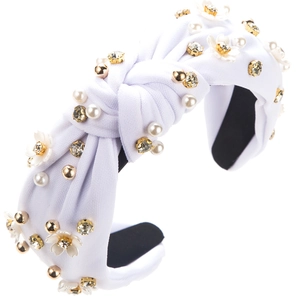 Détail du serre-tête tricoté blanc orné de perles, strass et fleurs en relief chic