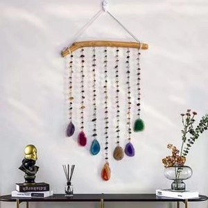 Detail of colorful agate slices hanging from a natural wood branch wind chime